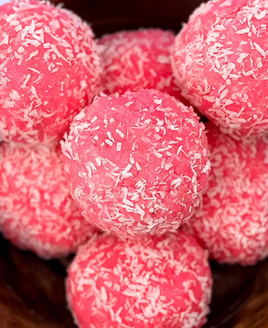 Rose coconut artisan ladoo Close-up of handmade pink rose coconut ladoo rolled in desiccated coconut.